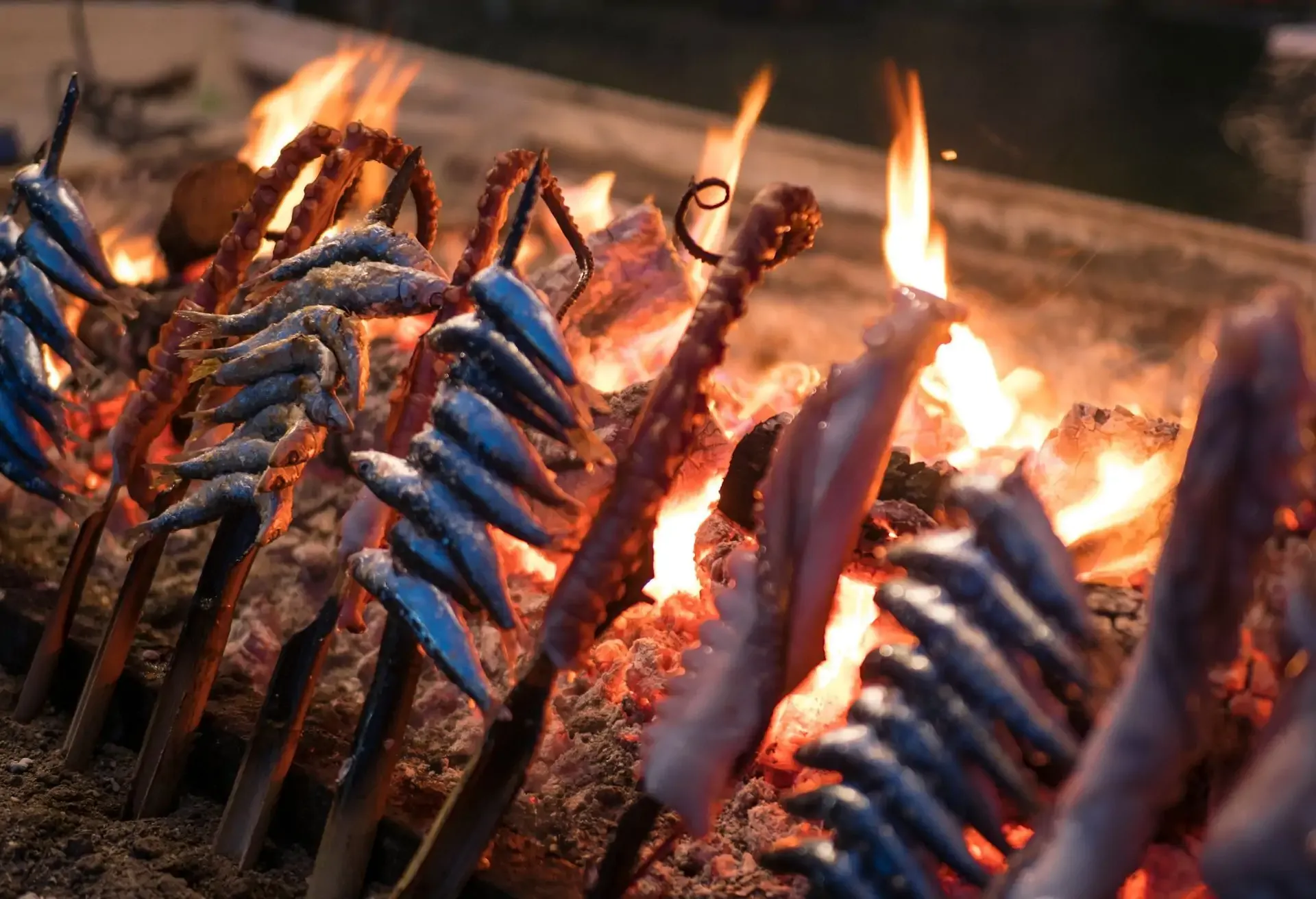 Traditional sardines and seafood skewered and grilled over an open flame.