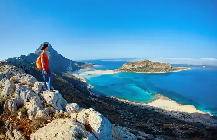 panoramic view on Balos beach, Crete, Greece. Woman, traveller stands on the cliff against sea background; Shutterstock ID 446003965; Brand (KAYAK, Momondo, Any): any